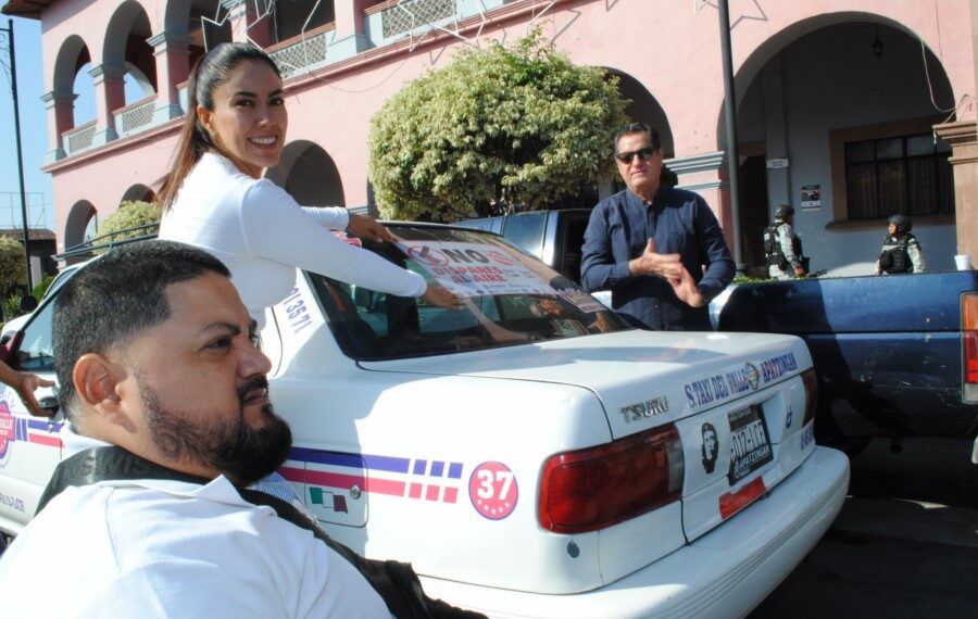 Fanny Arreola coloca un engomado mientras una victima de una bala perdida se encuentra a un costado